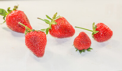 A lot of red ripe tasty strawberries lie on a white background