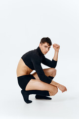 Fototapeta premium side view of a sporty man in shorts, socks and a sweater sits on a light background