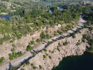 Rocky terrain overgrown with sparse vegetation, aerial view. Summer landscape from a bird's eye...