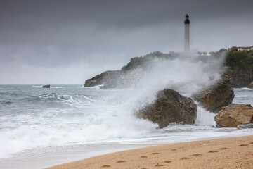 Fototapeta na wymiar Les vagues de la plage de Biarritz avec le phare en arrière plan