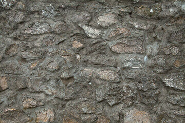 Wall of old ancient fortress. Stony wall texture. Medieval broadwall surface. Old antique stony bailey. Ancient castle wall.  Rubble face. Ruin wall.