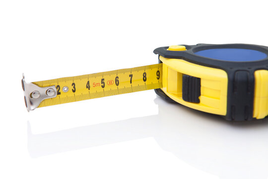Yellow measuring tape detail. Isolated on white background with shadow reflection