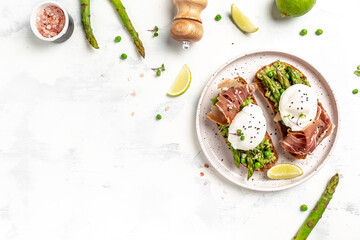 Ketogenic diet healthy breakfast asparagus with prosciutto, avocado and Benedict Poached eggs. Healthy food, diet lunch concept. Keto Paleo diet menu, top view