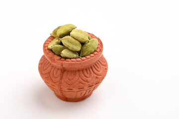 Fresh dried green cardamon seeds spice in a bowl on white background