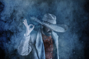 farmer hipster in a straw hat with brim in smoke smoking tobacco retro style wild west sambrero