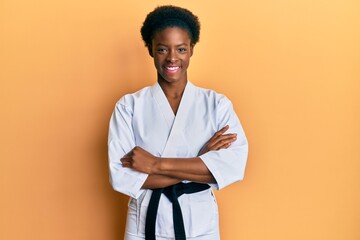 Young african american girl wearing karate kimono and black belt happy face smiling with crossed...
