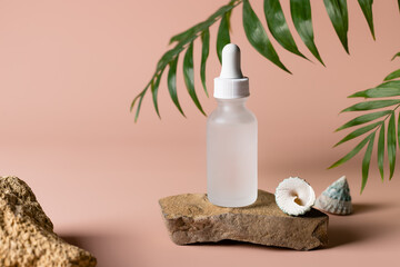 Moisturizing serum in glass bottle on a stone podium with seashells and green leaves background. SPA organic beauty concept. packaging for branding mockup