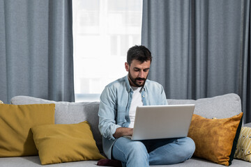 Young freelancer business man typing on his laptop computer an e mail with his CV as job offer to business companies that he is interested to work with