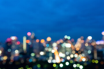 Abstract urban night light bokeh defocused of city and the office building. City and tower blurred background on twilight color sky. Night light of real estate as concept.