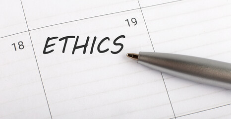 Text ETHICS on calendar planner to remind you an important appointment with a pen on isolated white background.