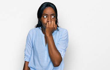 Young african american woman wearing casual clothes looking stressed and nervous with hands on mouth biting nails. anxiety problem.