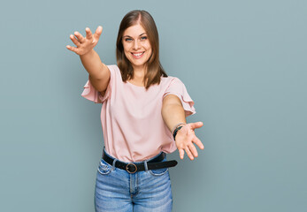 Beautiful caucasian woman wearing casual clothes looking at the camera smiling with open arms for hug. cheerful expression embracing happiness.