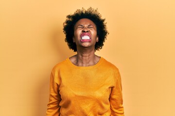 Young african american woman wearing casual clothes angry and mad screaming frustrated and furious, shouting with anger. rage and aggressive concept.