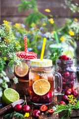 Healthy homemade cold lemonade with fresh berries and fruits in mason jar