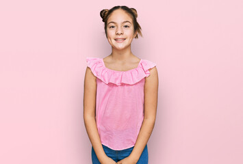 Beautiful brunette little girl wearing summer pink shirt looking positive and happy standing and smiling with a confident smile showing teeth