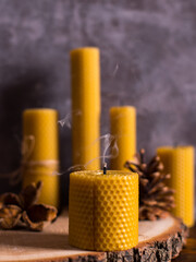 A handmade candle made of natural wax with the texture of honeycomb bees. Extinct smoke on the...