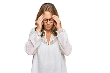 Middle age blonde woman wearing casual white shirt and glasses with hand on head for pain in head because stress. suffering migraine.