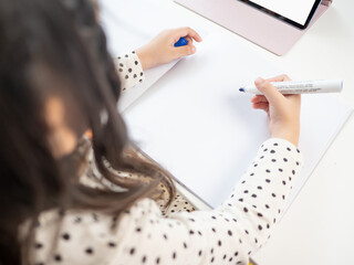 Children holding pen with blank white paper,home schooling concept