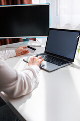 woman hand holding credit card and surfing on laptop white screen