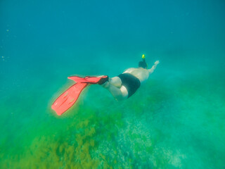 man swimming underwater with snorkeling musk