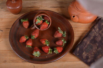 Strawberries in a wooden bowl. Nice fresh strawberries on the table against a wooden background