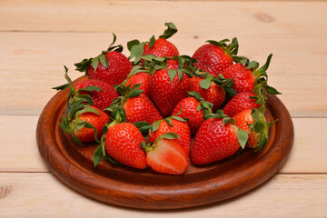 a bunch of ripe strawberries on a wooden board close-up