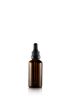 Serum, oil, acid, lotion in closed small dark brown dropper glass with pippete on white background, copy space. Spa products. Organic, natural cosmetic. Beauty, skincare concept.