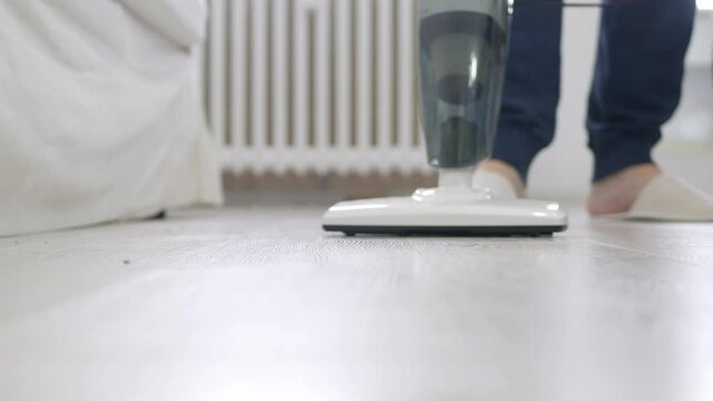Man Using a Vacuum Cleaner in Household Activities to Clean the Floor from Dust and Dirt.