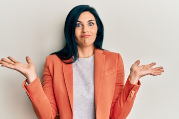 Young caucasian woman wearing business clothes clueless and confused with open arms, no idea and...