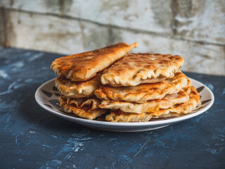 Fresh beef, hot pasties stacked in stacks on a ceramic light plate