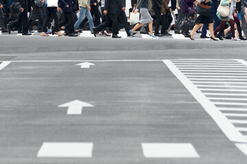 横断歩道を渡るビジネス街で働く人たち。People working in a business district crossing a pedestrian crossing.
