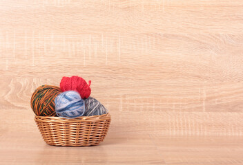Multicolored balls of wool on a wooden table