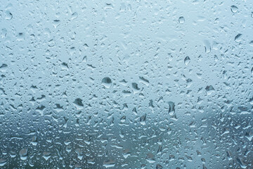 Raindrops on the transparent window pane in rainy weather.