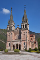 Fototapeta na wymiar Basilica of Santa María la Real de Covadonga (Cuadonga) in Asturias (Asturies). Neo-Romanesque style temple designed by Roberto Frassinelli and built entirely in pink limestone.