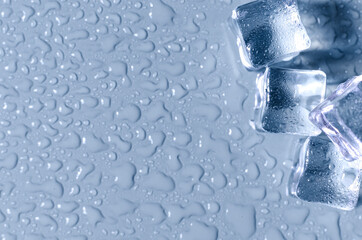 Transparent artificial ice cubes on a blue background of kopi space. Background of transparent ice...
