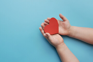 A heart in the hands of a child. Children's love and health