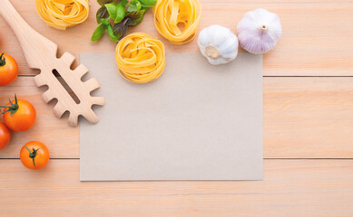 Food background for tasty Italian dishes with blank brown paper and vintage pasta ladle on wooden background. Top view italian foods concept and menu design with copy space.