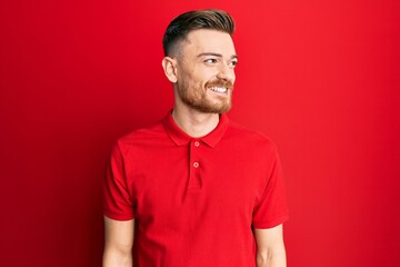 Young redhead man wearing casual clothes looking to side, relax profile pose with natural face and...