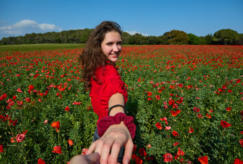woman shaking hands in red poppy field
