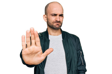 Young hispanic man wearing casual clothes doing stop sing with palm of the hand. warning expression with negative and serious gesture on the face.