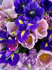 Beautiful and fragrant blooming tulips, irises, daisy flowers close up. Perfect spring phone screen shot. Pink and purple flowers mix.