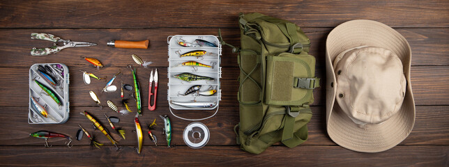 Fishing tackle - fishing spinning rod, hooks and lures on wooden background. Active hobby...