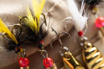 Fishing tackle - fishing spinning rod, hooks and lures on wooden background. Active hobby...