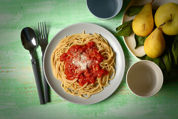 plate of spaghetti with tomato sauce with fruit around - closeup