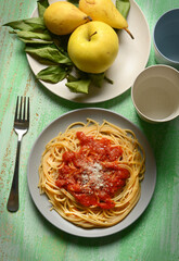 plate of spaghetti with tomato sauce with fruit around - closeup