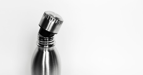 Close-up of bottle neck with open cap on white background with copy space. Reusable steel thermo...