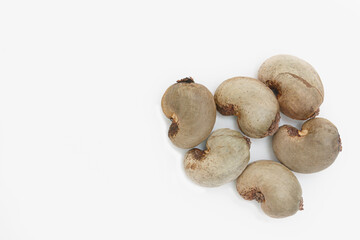 Cashew nuts dried with shell waiting to be processed on white background