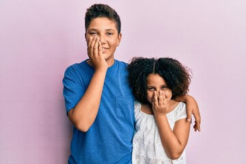 Obraz premium Young hispanic family of brother and sister wearing casual clothes together laughing and embarrassed giggle covering mouth with hands, gossip and scandal concept