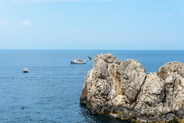 young man walking from the rock into the sea