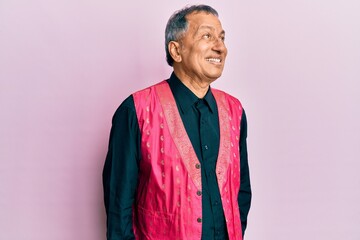Obraz premium Middle age indian man wearing traditional indian clothes looking away to side with smile on face, natural expression. laughing confident.